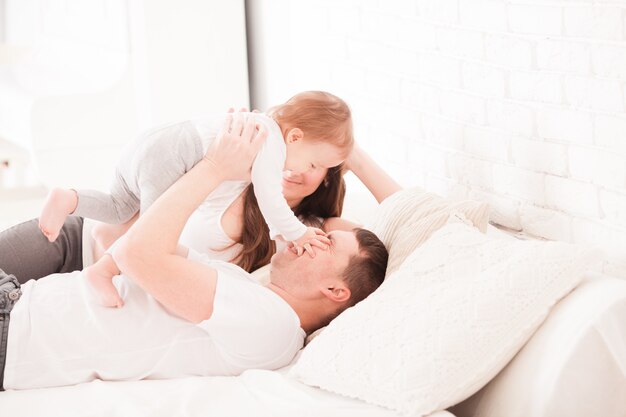 Morgen im Bett, junge Familie mit Kleinkindbaby im Schlafzimmer