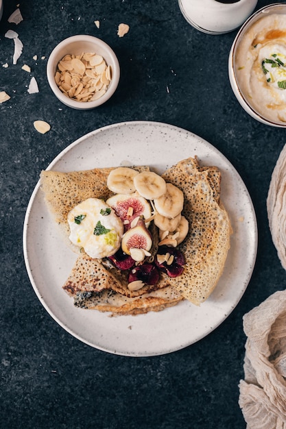 Morgenfrühstück mit Crepes mit frischen Früchten, Ricotta und Ahornsirup.