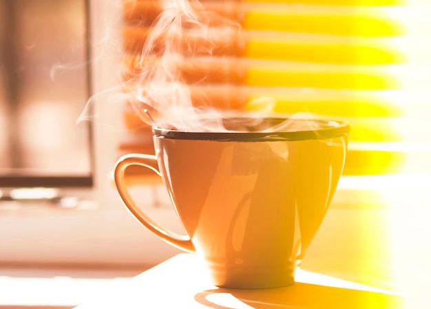 Morgenkaffee auf der Fensterbank Dampf über der Keramiktasse