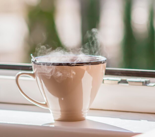 Morgenkaffee auf der Fensterbank Dampf über der Keramiktasse
