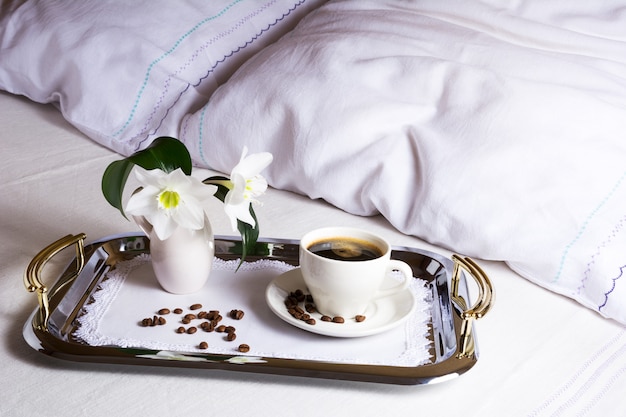 Morgenkaffee im Bett auf elegantem silbernem Serviertablett