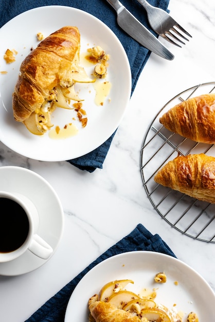 Morgenkaffee mit Croissanten, gefüllt mit karamellisierten Birnen, Haselnüssen und Ricotta