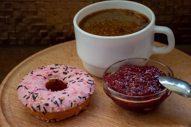 Morgenkaffee mit Donut und Marmelade