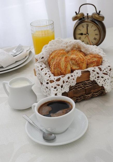 Morgenkaffee mit frisch gebackenen Sesambrötchen, Saft und Milch