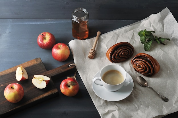 Morgenkaffee mit Kaffee und Brötchen mit Mohn, Äpfeln und Honig