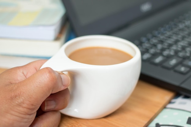 Morgenkaffeetasse und Laptop zum Arbeiten