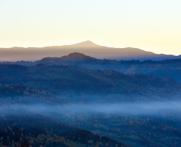 Morgennebel im Herbstkarpaten. Tagesanbruch Landschaft Berggipfel.