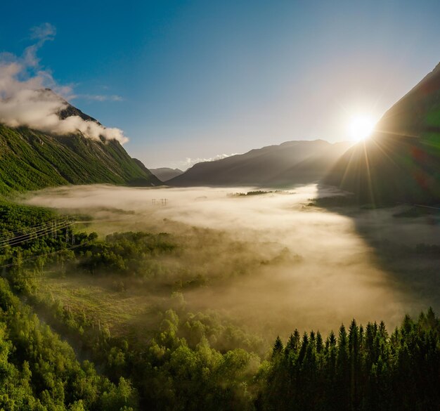 Morgennebel über dem Tal zwischen den Bergen im Sonnenlicht. Nebel und schöne Natur von Norwegen-Luftaufnahmen.