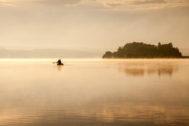 Morgens bei sonnenaufgang auf dem see angeln