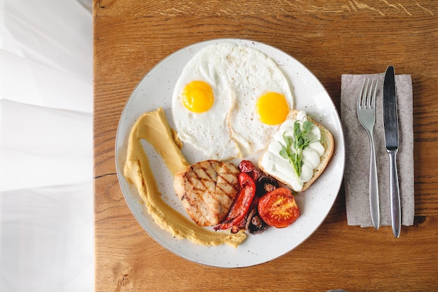 morgens in einem schönen café zum frühstück spiegelei mit tomate und hähnchen