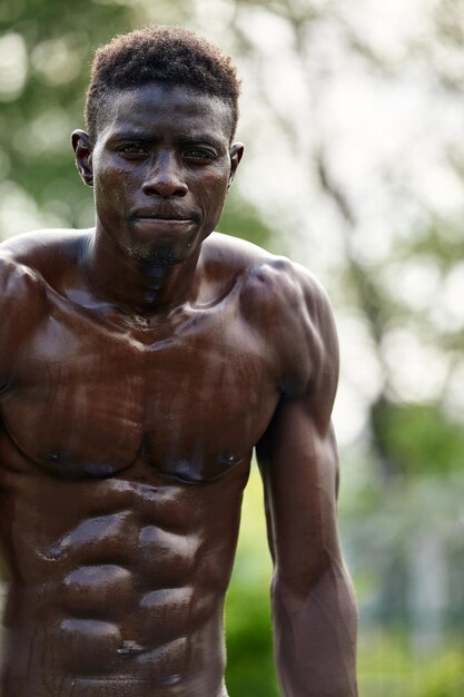 Morgens trainieren Junger starker afrikanischer Mann in Sportbekleidung, der im Freien trainiert Sporttrainingskonzept Gesunder aktiver Lebensstil TRX