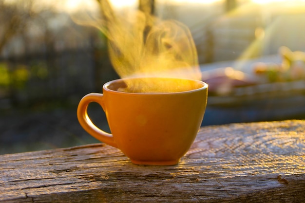 Morgentasse Kaffee auf Holztisch bei Sonnenaufgang