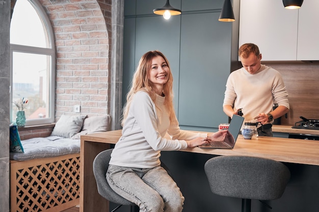 Morgentee vor der Arbeit zu Hause mit mobilem Computer