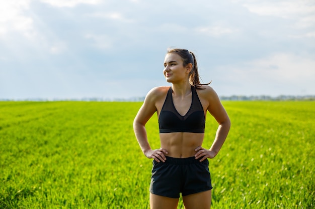 Morgentraining. Gesundes Lebensstilkonzept. Junge attraktive Frau in Sportkleidung macht ihre Hand vor dem Training in der Natur im Morgengrauen strecken. Muskelerwärmung