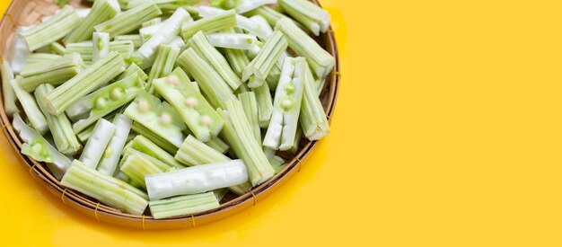 Moringa oleifera in Bambusplatte auf gelbem Hintergrund