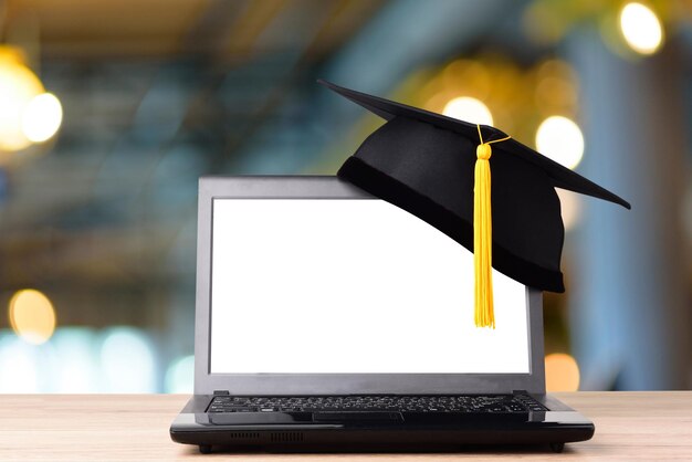 Mortarboard sobre el portátil en la mesa