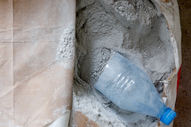 Mortero de polvo gris seco en una bolsa de papel