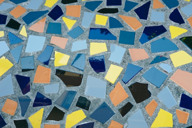 Mosaico de azulejos rotos sobre fondo gris fuera del suelo colorido texturizado