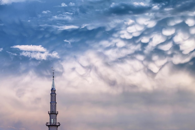 Moschee mit Halbmond auf Turmspitze auf dem Hintergrund stürmischer düsterer Wolken