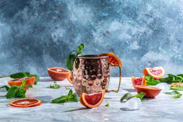 Moscow Mule Cocktail in Kupferbecher mit Blutorangen-Ingwer-Bier-Wodka und Minz-Freeze-Motion-Splash