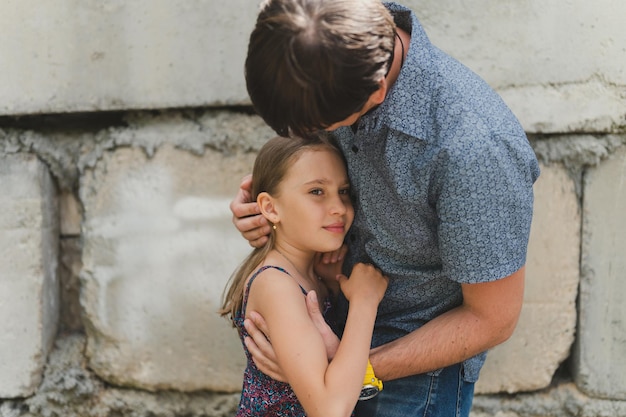 Moskau 15.06.2022 Mann Vater hat Zeit mit Kind Tochter Mädchen neun Jahre umarmt und glättet ihr Haar glücklicher Vater mit Kind echtes Leben authentische alltägliche Vaterschaftsmomente väterliche Liebe Fürsorge