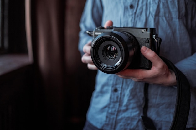 Moskau, Russland, 14. März 2019 Fujifilm GFX50s Kamera Fujifilm spiegellose Nahaufnahme der Hand, die die Kamera spiegellose Kamera in der Hand eines jungen Mannes auf einem Studiohintergrund hält