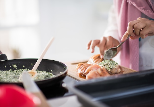 Moslemische arabische traditionelle Frau in der Küche, die Lebensmittel zum Mittagessen zubereitet