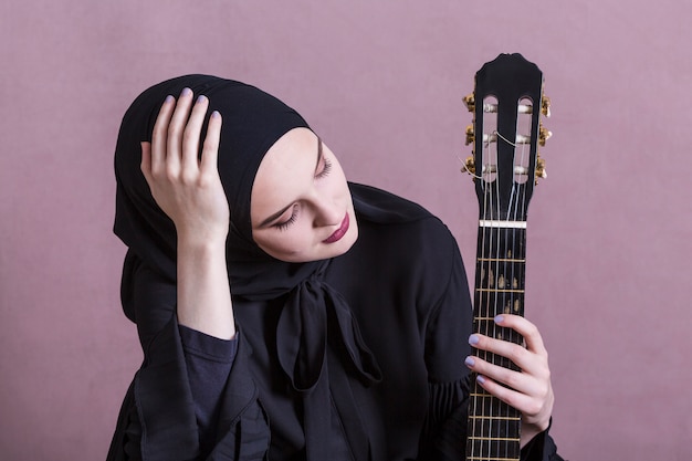 Foto moslemische frau, die auf der gitarre spielt