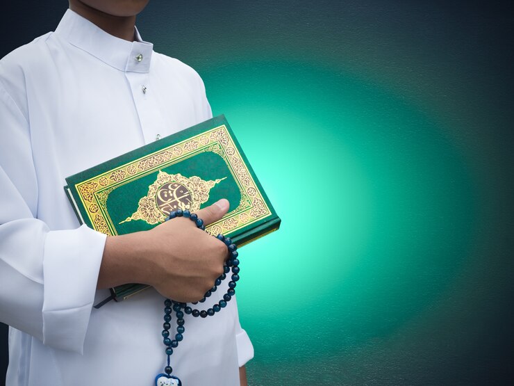 Moslemischer Junge, der heiliges Buch von Allah oder von moslemischem Gott hält
