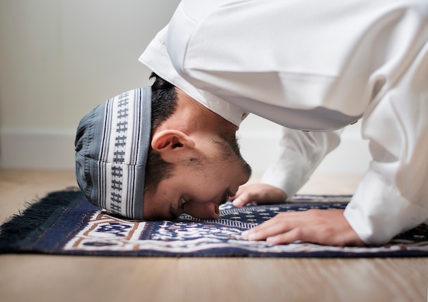 Moslemischer junge, der in sujud-haltung betet