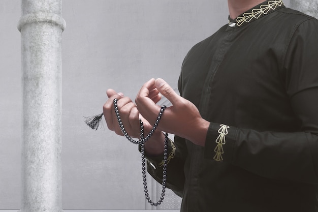 Moslemischer Mann, der mit Gebetsperlen betet