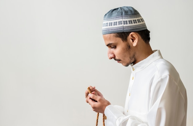Moslemischer Mann, der mit Tasbih während Ramadans betet