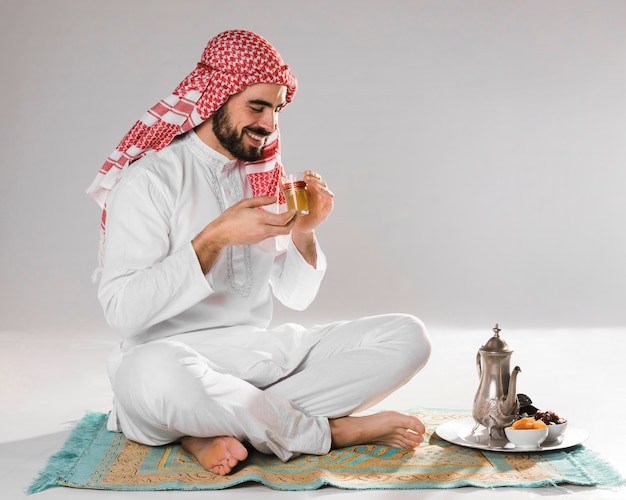 Foto moslemischer mann des smiley genießt traditionellen tee