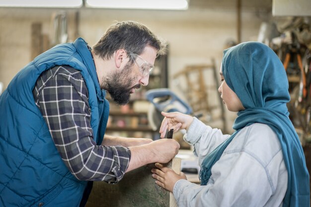 Moslemischer Mann und Frau in der Werkstatt, die zusammenarbeitet