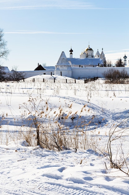 Mosteiro Pokrovskiy na margem do rio congelado em Suzdal