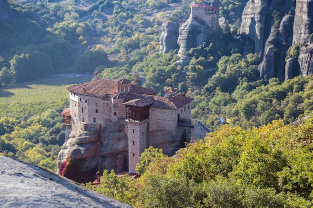 Mosteiros de São Rousanou e São Nicolau Anapausas imenso pilar monolítico folhagem verde Meteora