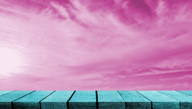 Foto mostrador de mesa de estante de exhibición de tablero de madera verde azulado con espacio de copia para telón de fondo publicitario y fondo con fondo de nube de cielo rosa
