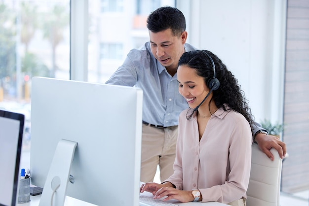 Mostrando a ela as coisas por aqui Foto de dois jovens agentes de call center usando um computador no escritório durante o dia