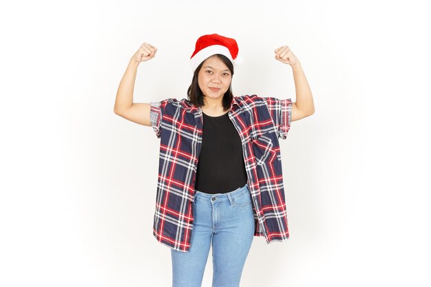 Mostrando a força e os braços erguidos de uma bela mulher asiática vestindo uma camisa xadrez vermelha e um chapéu de papai noel