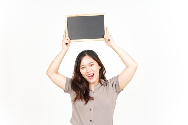 Mostrando apresentando e segurando o quadro-negro em branco da linda mulher asiática isolada no branco