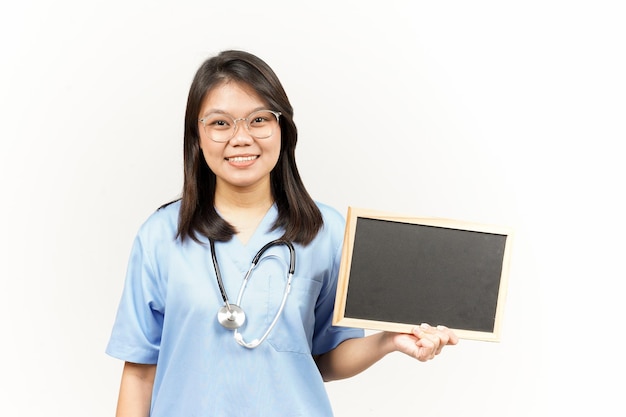 Mostrando apresentando e segurando o quadro-negro em branco do jovem médico asiático isolado no fundo branco