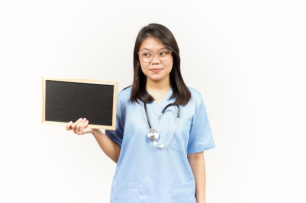 Mostrando apresentando e segurando o quadro-negro em branco do jovem médico asiático isolado no fundo branco
