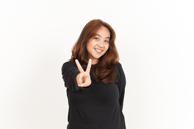 Mostrando dos dedos de hermosa mujer asiática vistiendo camiseta negra aislado sobre fondo blanco.