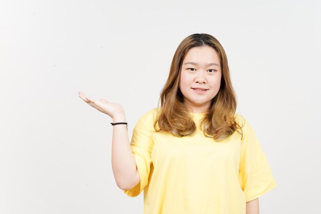 Mostrando e apresentando o produto na palma aberta da bela mulher asiática vestindo camiseta amarela