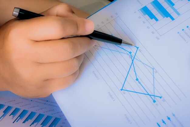 Mostrando gráfico financeiro, conceito de negócio, análise do plano de vendas, relatório de negócios, estação de trabalho comercial com papelada