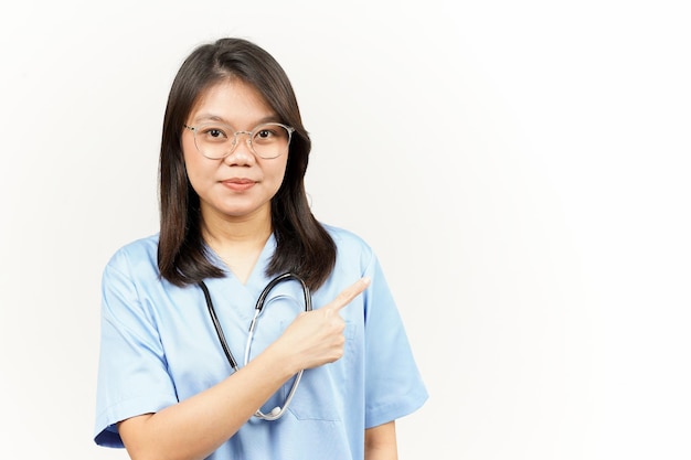 Mostrando o produto e apontando o lado do jovem médico asiático isolado no fundo branco