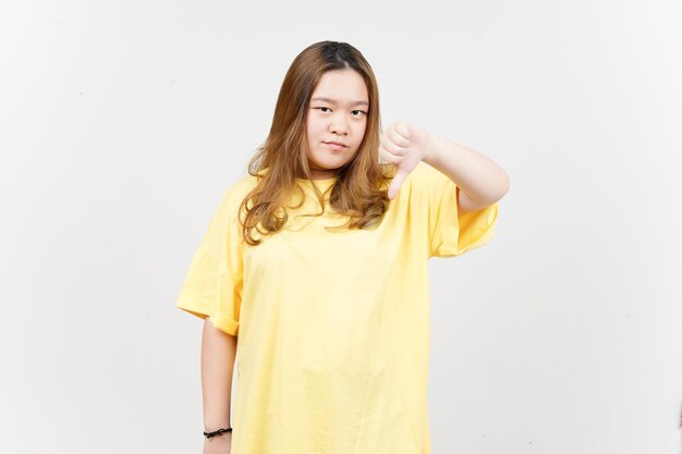 Mostrando os polegares para baixo da linda mulher asiática vestindo camiseta amarela isolada em fundo branco