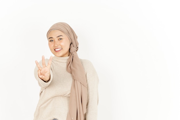 Mostrando os três dedos de uma linda mulher asiática usando um hijab isolado no fundo branco