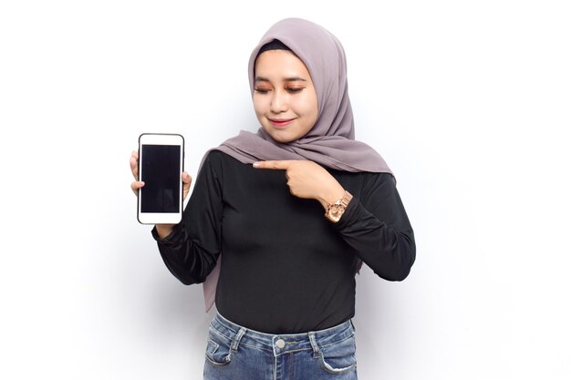 Mostrando en la pantalla en blanco del teléfono inteligente de jóvenes hermosas mujeres asiáticas musulmanas visten velo Hijab