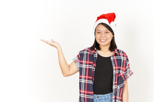 Mostrando y presentando el producto en la palma de la mujer asiática vistiendo camisa roja a cuadros y gorro de Papá Noel